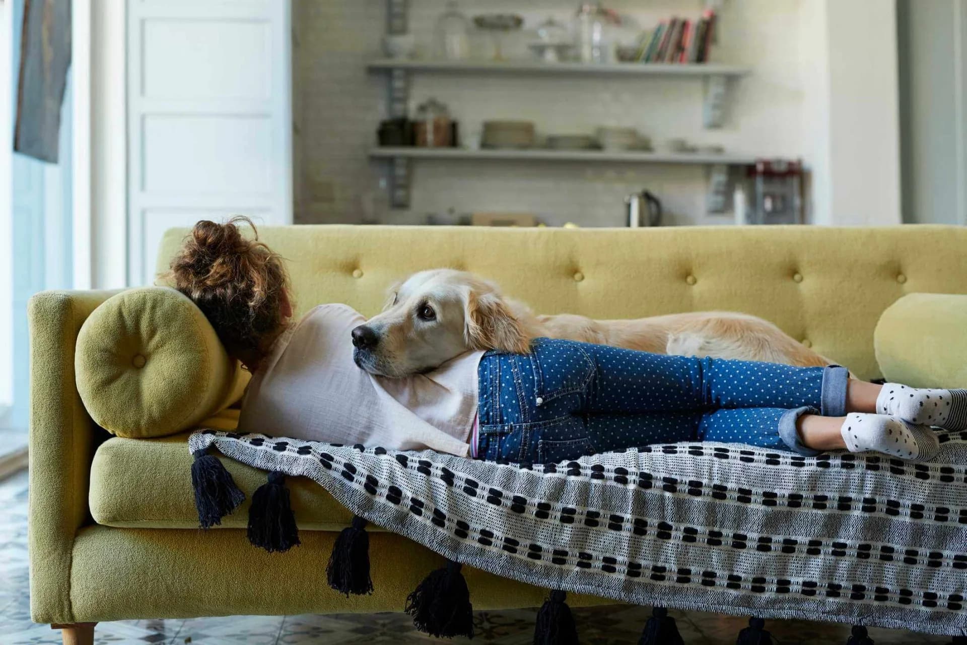 Una donna riposa sul divano di casa con il suo cane